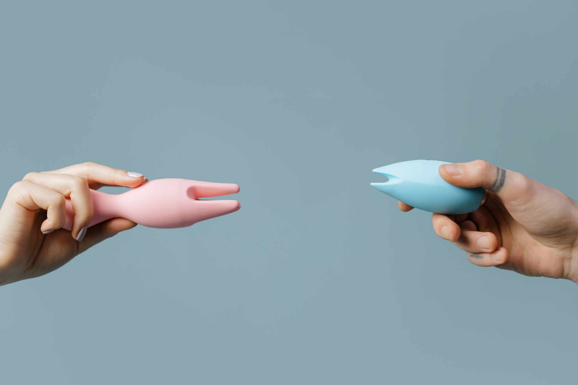 A hand holding a fresh lemon against a vivid yellow background, symbolizing the bright, stimulating sensation of lemon vibrator technology.