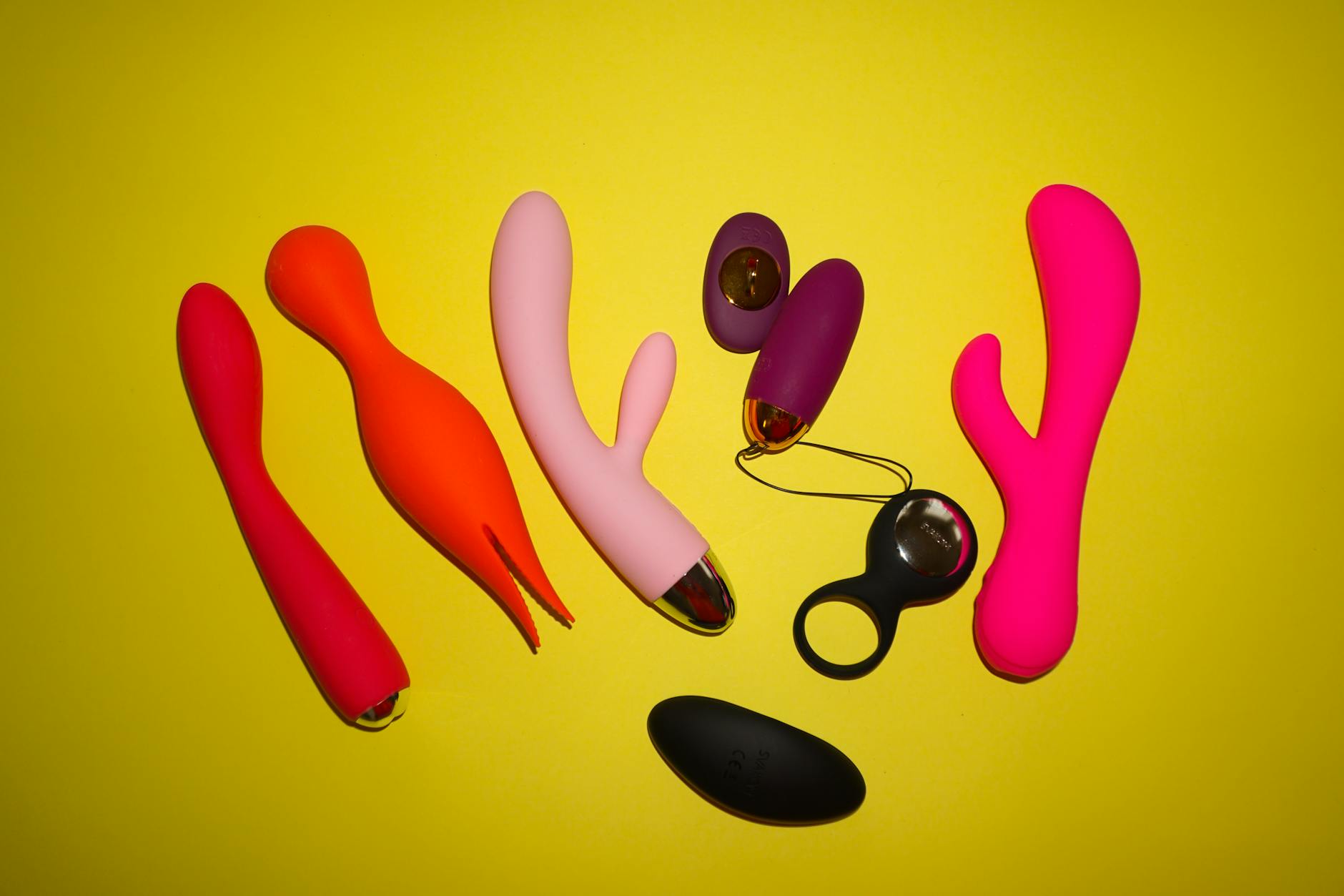Close-up of a woman holding a vibrator with art books nearby, showing intimate personal pleasure