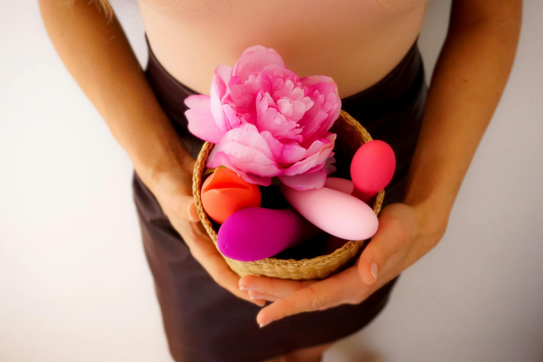 Blue vibrator surrounded by flowers and citrus on a sunny yellow background